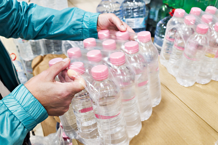 Hands with pack of water bottles